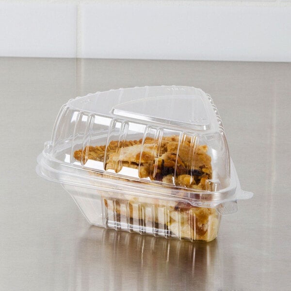 A Dart clear plastic container with a slice of pie inside.