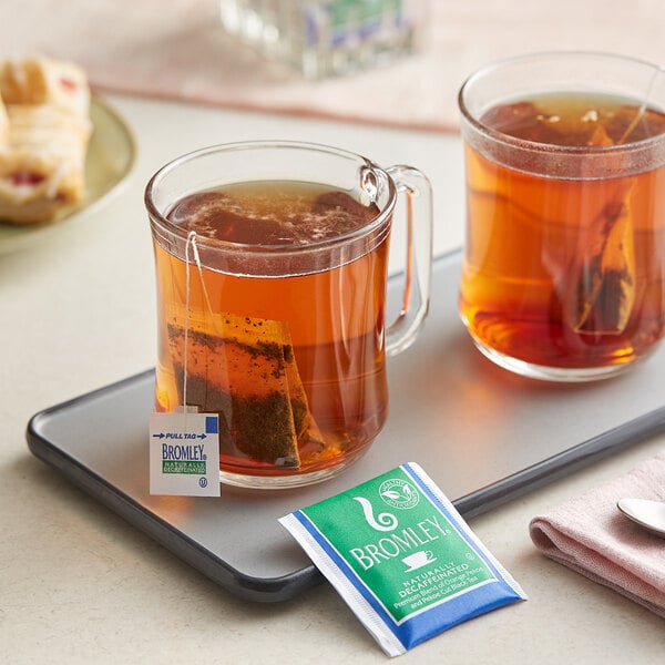 A tray with two glass mugs of Bromley decaf tea with tea bags.