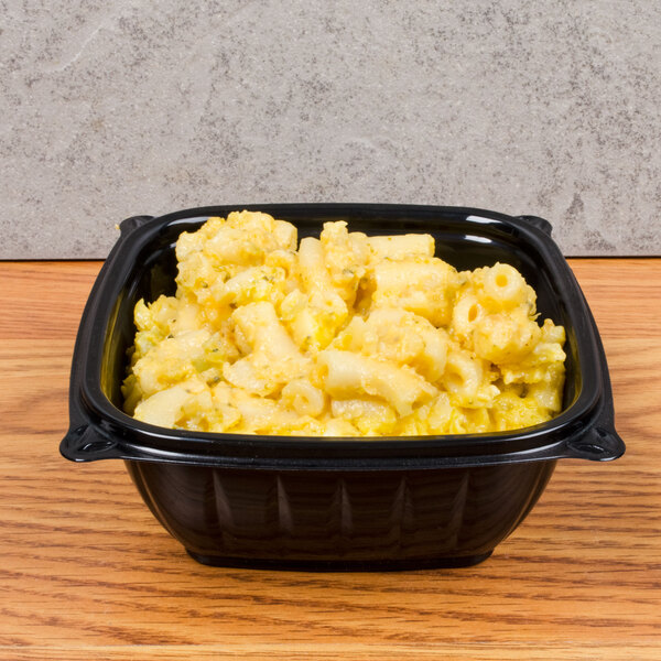 A Dart black plastic square bowl filled with macaroni and cheese.