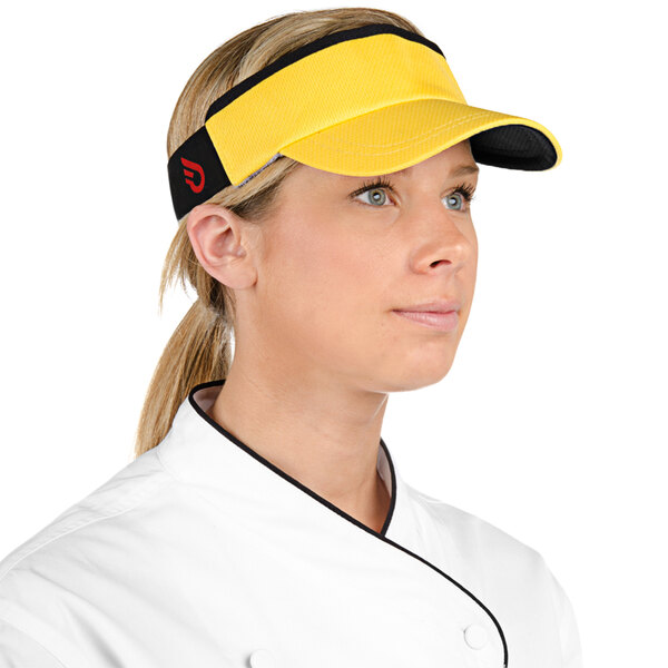 A woman in a chef's uniform wearing a yellow Headsweats visor.