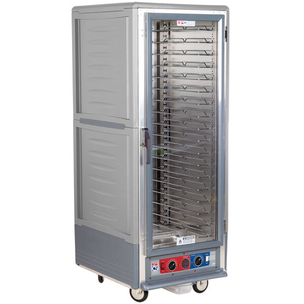 A large gray metal holding and proofing cabinet with clear door and wheels.