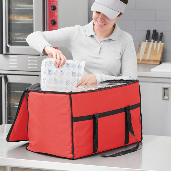 A woman opening a red Choice insulated food delivery bag.