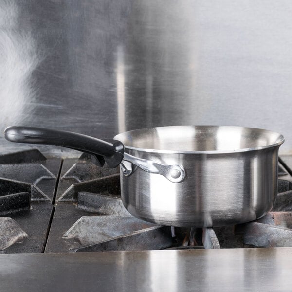 A Vollrath stainless steel sauce pan on a stove.
