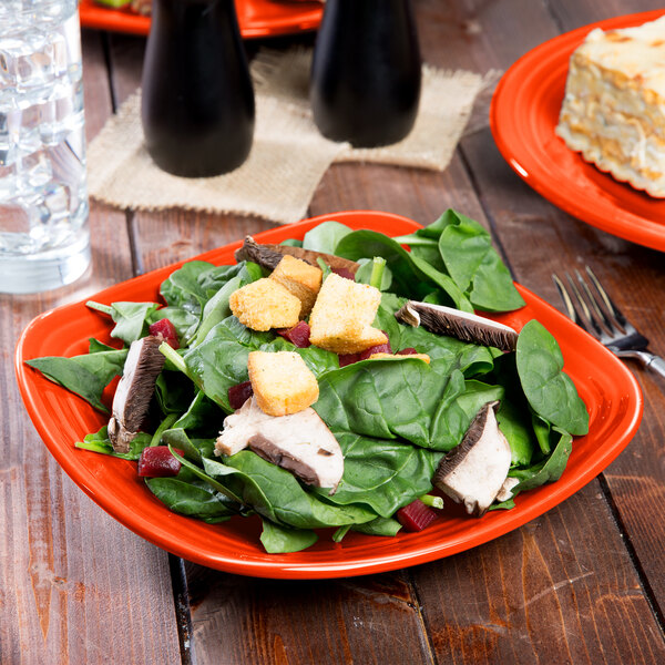 A Fiesta® luncheon plate with salad on a table.
