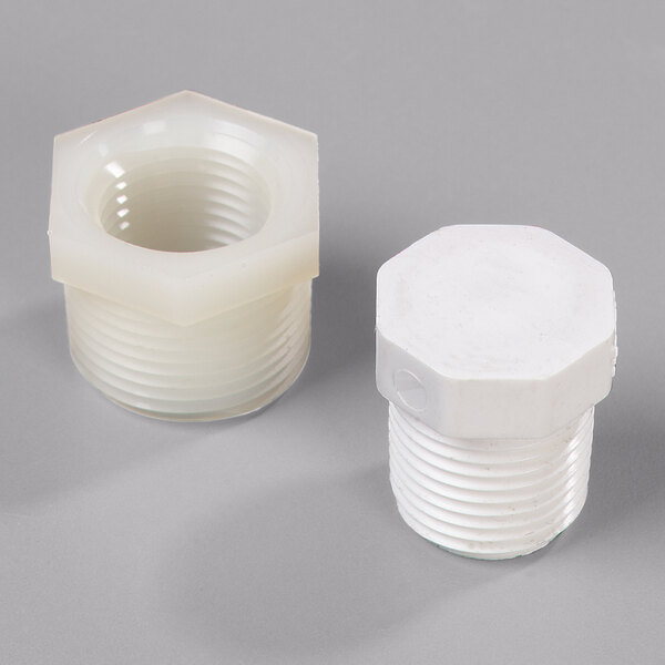 A Carlisle tabletop drain plug assembly with two white plastic plugs and a white cap.