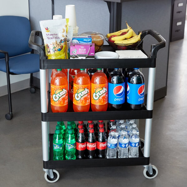 A black Cambro utility cart with snacks and drinks on it.