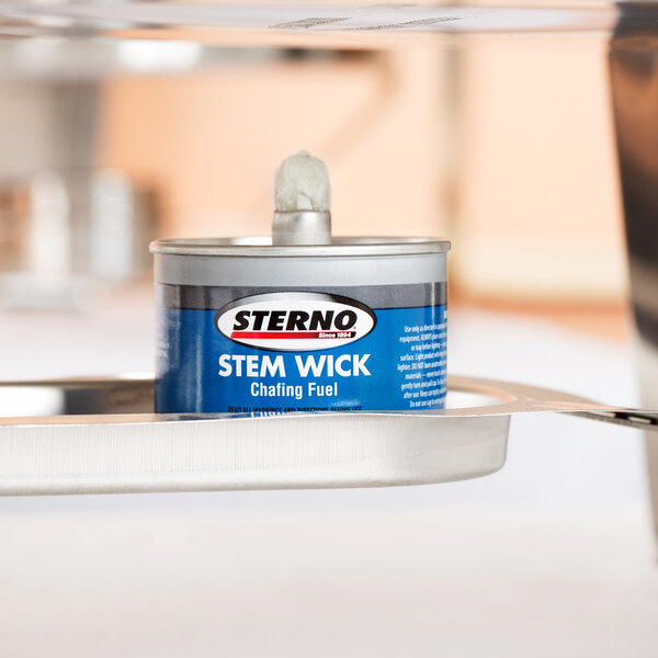 A small Sterno container with a blue label on a metal tray.