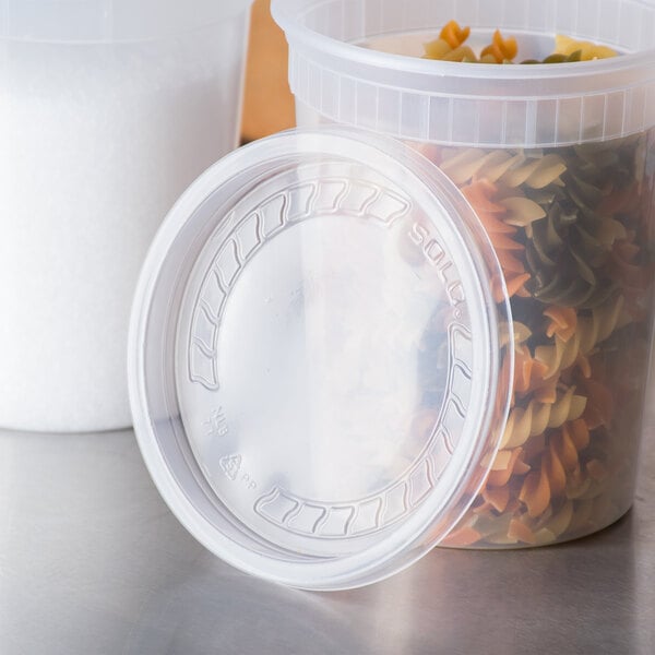 A Solo clear plastic container with a lid filled with spiral pasta.