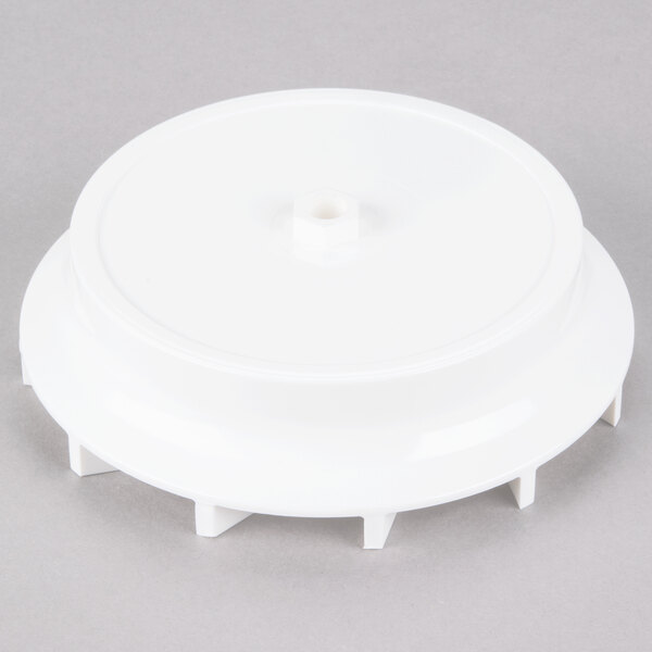 A white plastic Waring extractor / impeller with a hexagonal hole.