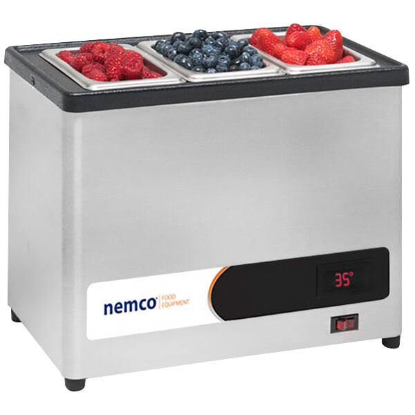A Nemco countertop condiment chiller with blueberries, raspberries, and a clear lid.