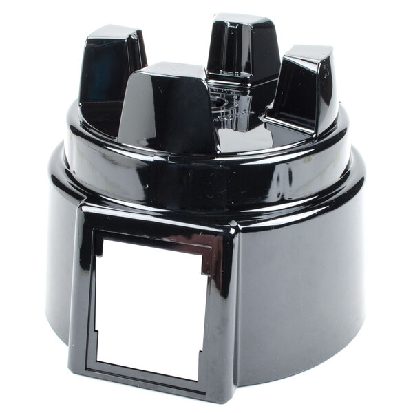 The top housing of a Waring blender, a black plastic object with a white label on top.