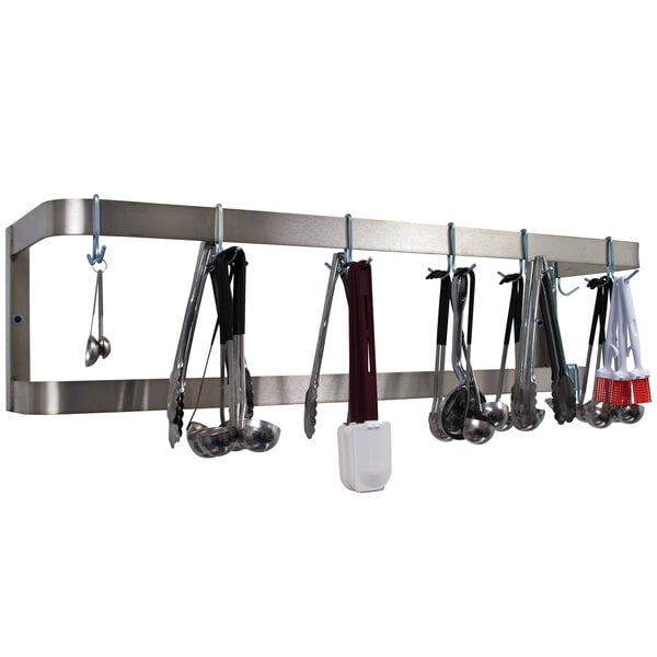 A stainless steel Advance Tabco double line pot rack with kitchen utensils hanging on it.