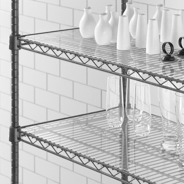 A Regency shelf with clear PVC liners holding white vases and glassware.