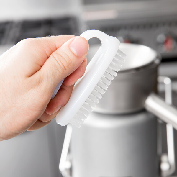 A hand holding a Waring juice extractor cleaning brush.
