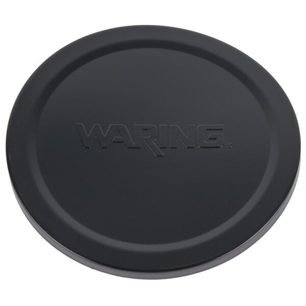 A black circular Waring storage lid with text on it.