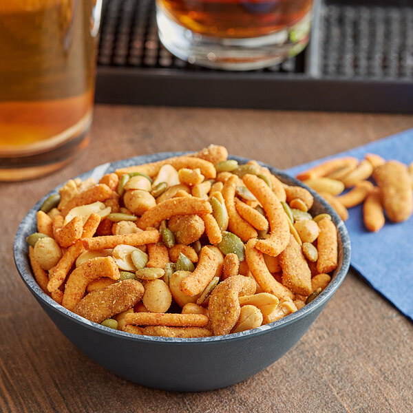 A bowl of Fiesta Sunshine Snack Mix on a table in a cocktail bar.