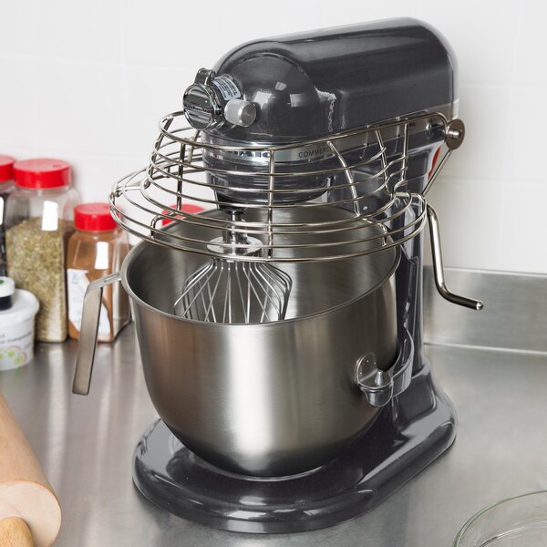 A KitchenAid commercial mixer with a glass bowl and whisk on a counter.