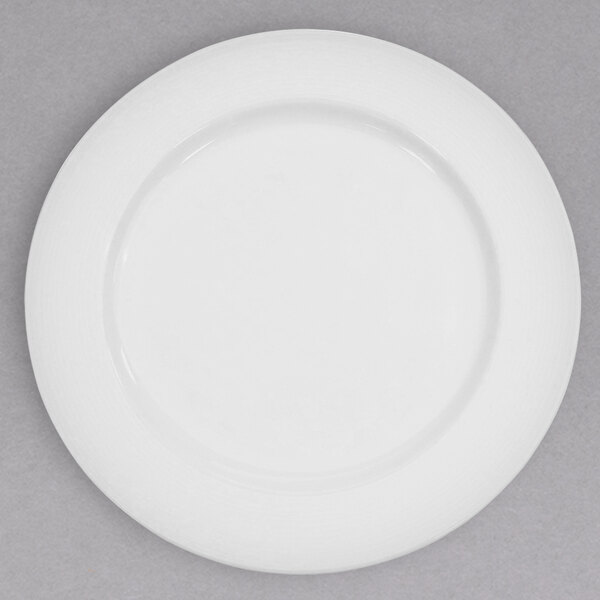 A CAC Harmony super white porcelain plate with a white rim on a gray surface.