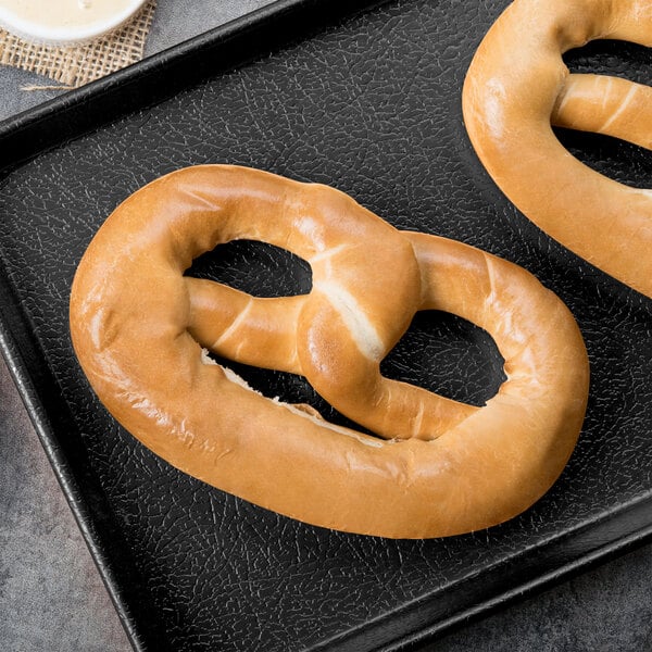 A PretzelHaus unsalted pretzel on a black tray.