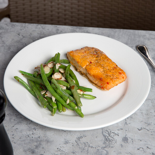 A CAC Harmony porcelain plate with salmon and green beans on a table.