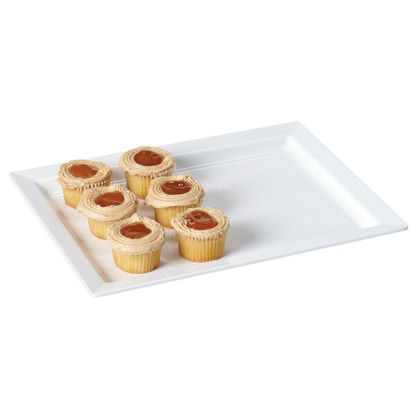 A white rectangular wide rim melamine display tray with six cupcakes on it.