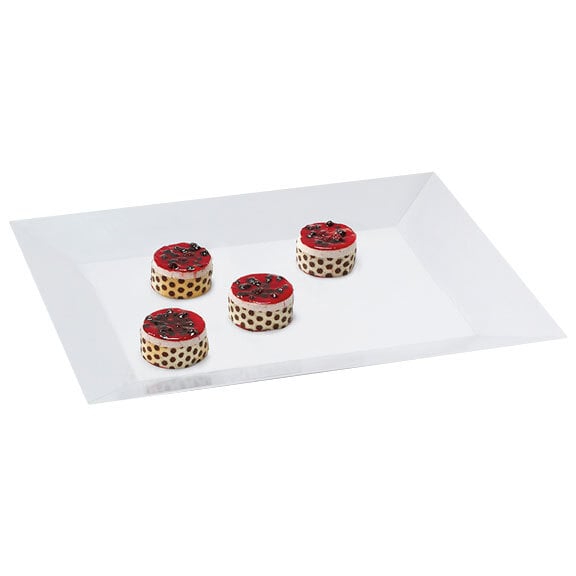 A white GET rectangular tray with red and white round cakes with black spots.