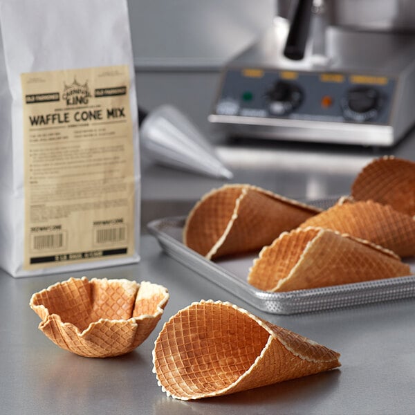 A bag of Carnival King Old Fashioned Waffle Cone mix sits on a table next to waffle cones.