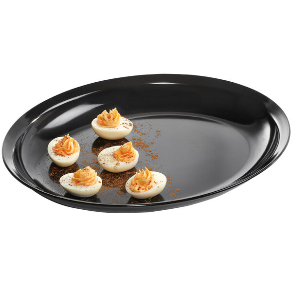 A black oval Milano platter with deviled eggs on it.