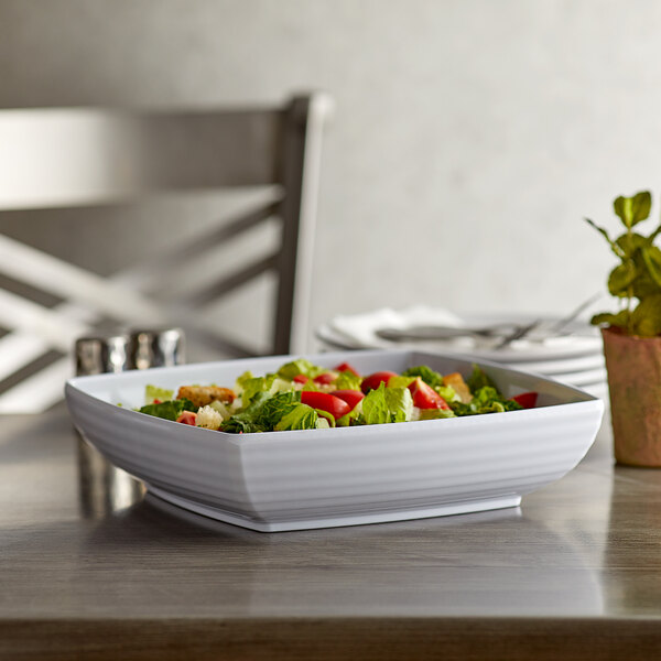 A white GET Milano melamine bowl with salad on a table.