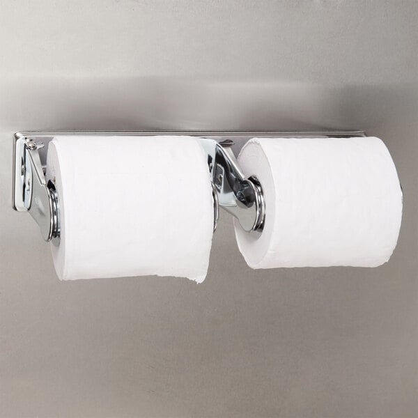 A Bobrick multi-roll toilet paper dispenser with two rolls on a chrome wall.