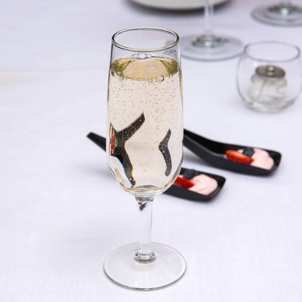 A Libbey flute glass filled with champagne on a table