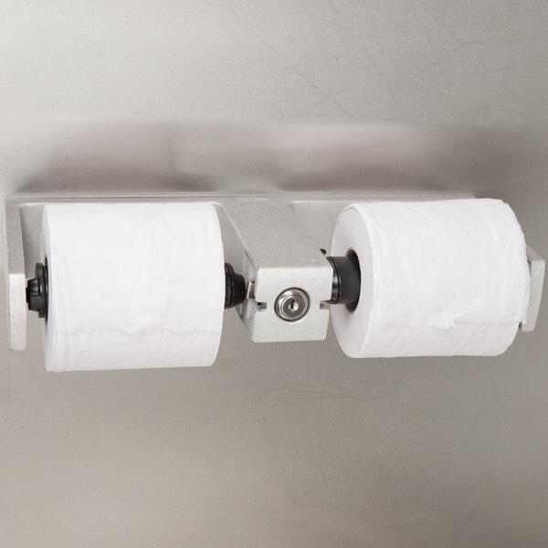 A Bobrick surface-mounted toilet paper holder with two rolls of toilet paper.