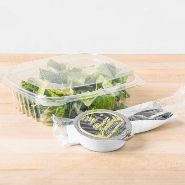 A Genpak clear plastic deli container of lettuce with a high dome lid.