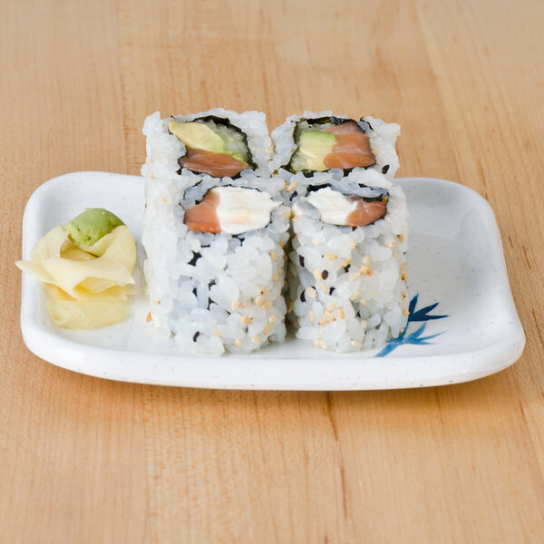 A Thunder Group Blue Bamboo rectangular melamine plate with a sushi roll and a slice of avocado.