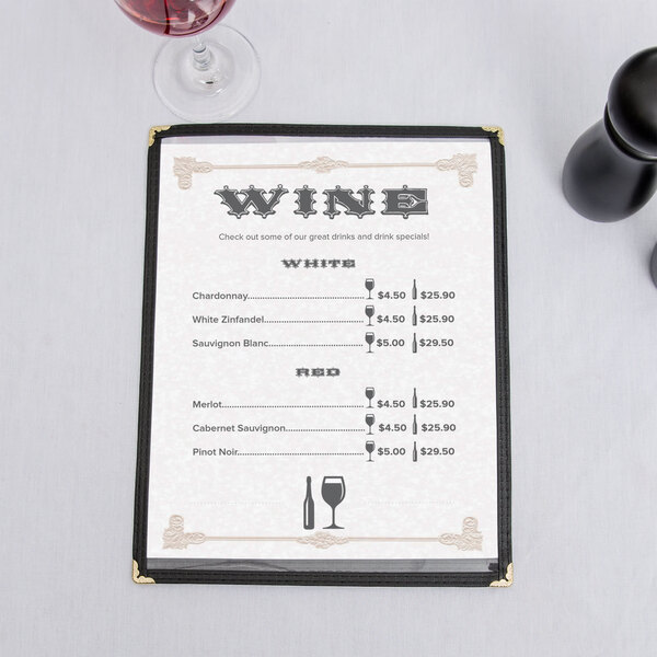 A tan menu with a scroll border on a table with wine glasses and wine bottles.