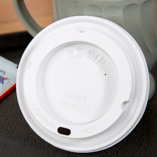 A white plastic lid on a Dinex Turnbury mug.