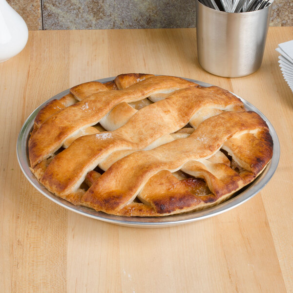 A pie in a Vollrath aluminum pie pan on a table.