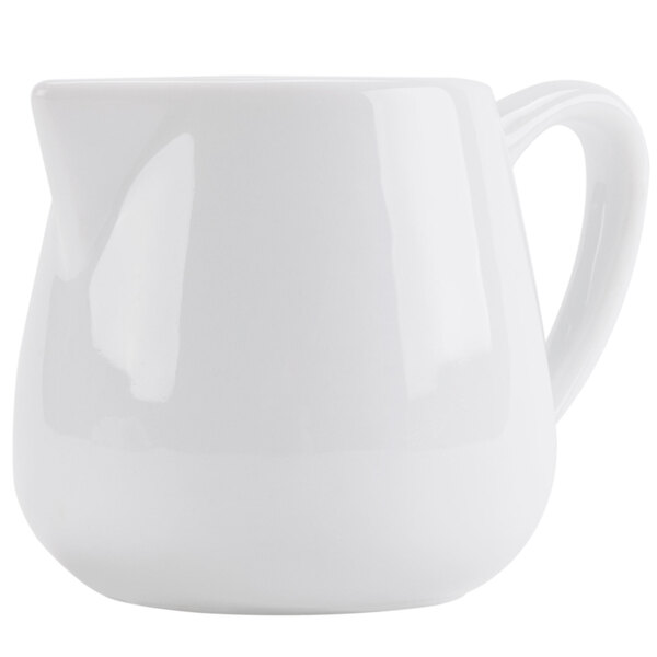 A close-up of a CAC Bright White porcelain creamer with a handle.