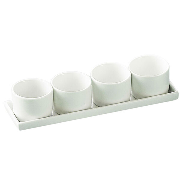 A CAC bright white porcelain tray with four white round bowls on it.