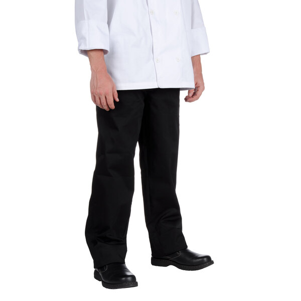 The lower half of a person wearing Chef Revival black chef pants and black shoes.