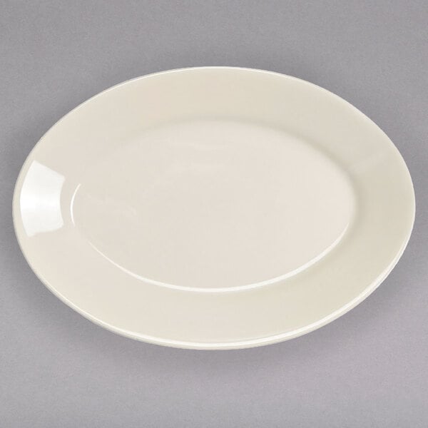 A white oval china platter with a rolled edge on a gray surface.