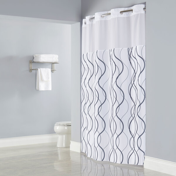 A white Hookless shower curtain with gray wave pattern.