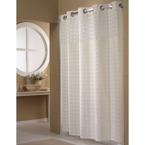 A white Hookless shower curtain with raised square patterns on it.