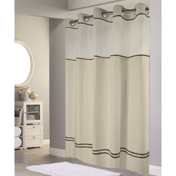 A Hookless sand shower curtain with brown and white stripes and a translucent window.