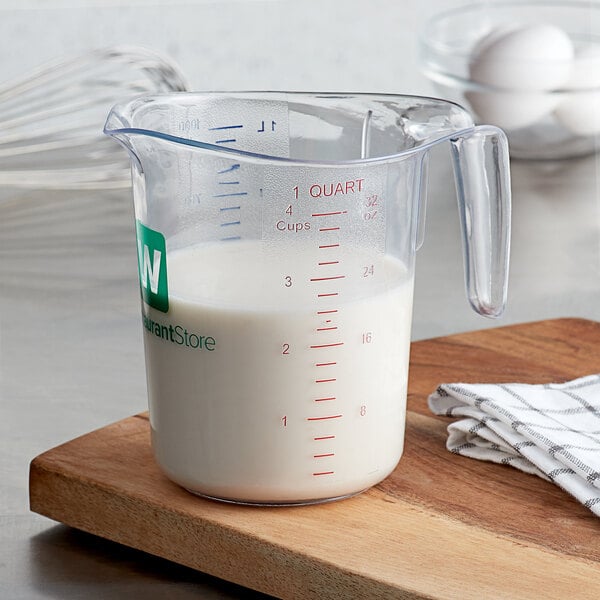 A clear plastic measuring cup filled with milk.