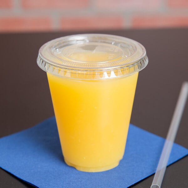 A Solo Ultra Clear plastic lid with a straw slot on a plastic cup with a yellow drink.