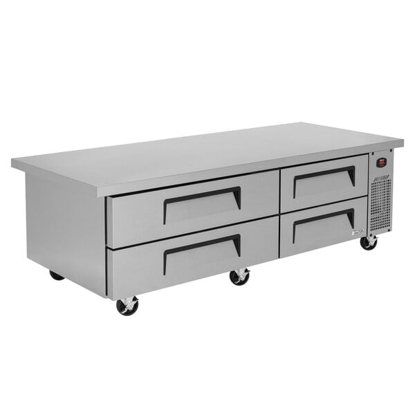 A Turbo Air stainless steel chef base with four grey drawers.