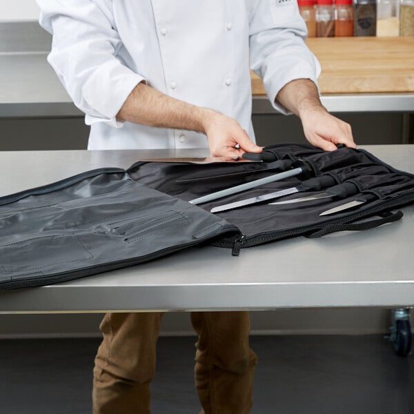 A chef holding a Victorinox knife set in a black bag.
