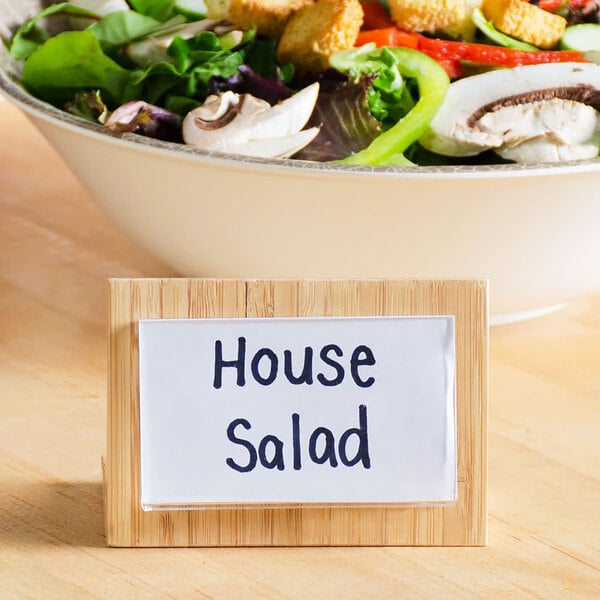 A Cal-Mil bamboo displayette with a house salad sign on a bowl of salad.