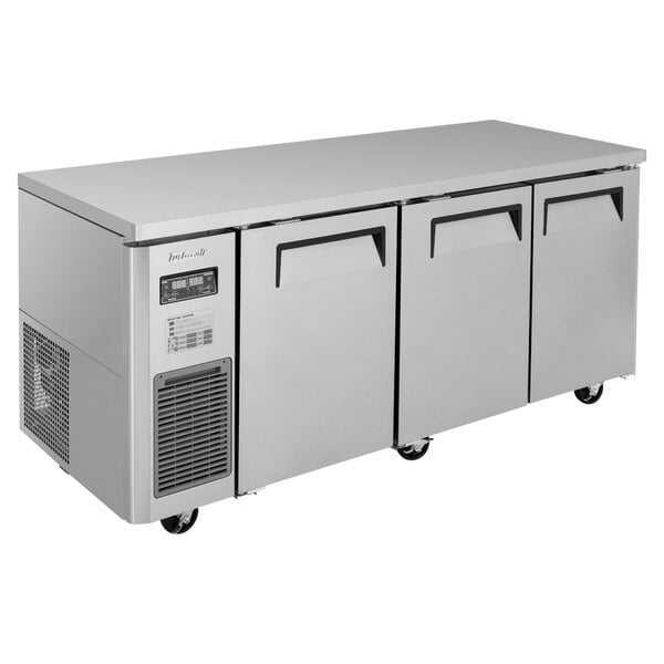 A large stainless steel Turbo Air undercounter refrigerator / freezer with three doors and a black handle.
